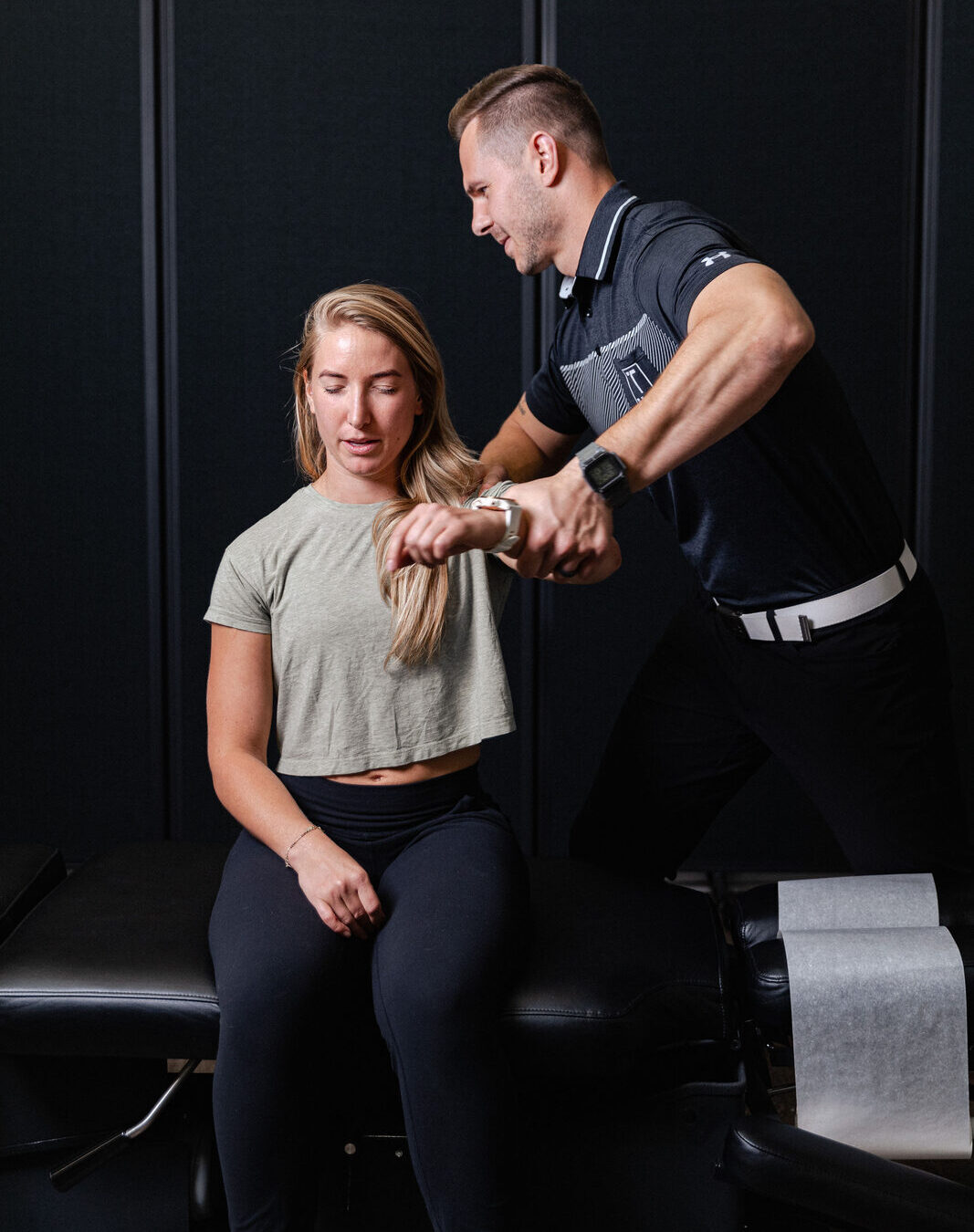 Provider carefully assessing a patient's shoulder and arm mobility at Transform Wellness